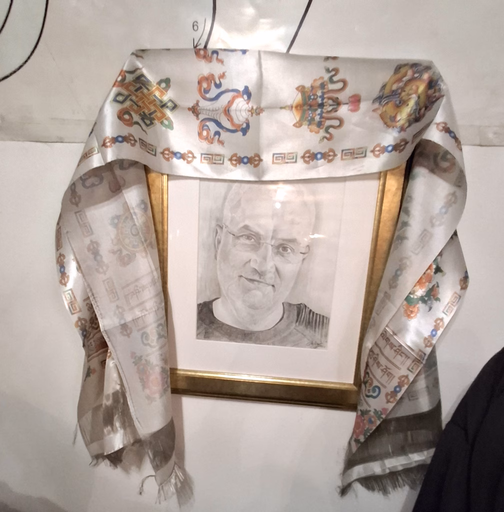 Portretul lui Argesanu, in creion, inramat si acoperit partial cu o esarfa cu simboluri decorative, expus pe un perete.